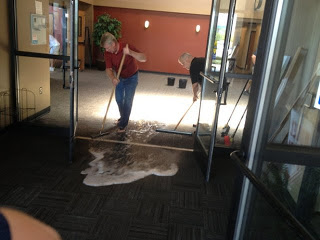 a man mopping out a flooded hallwaty