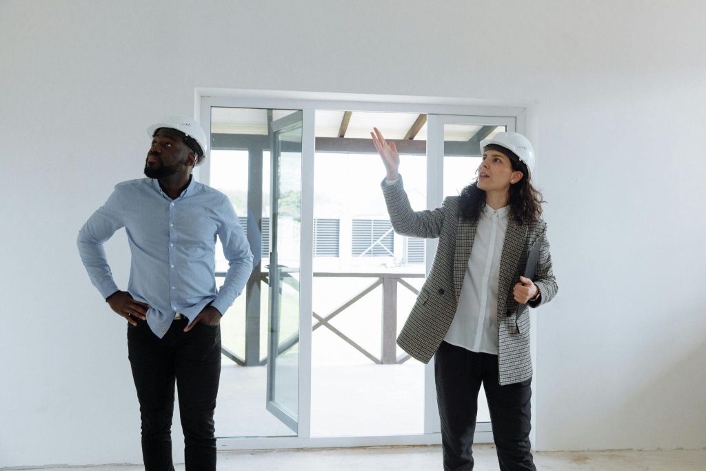Man and woman in hard hats inspecting a building
