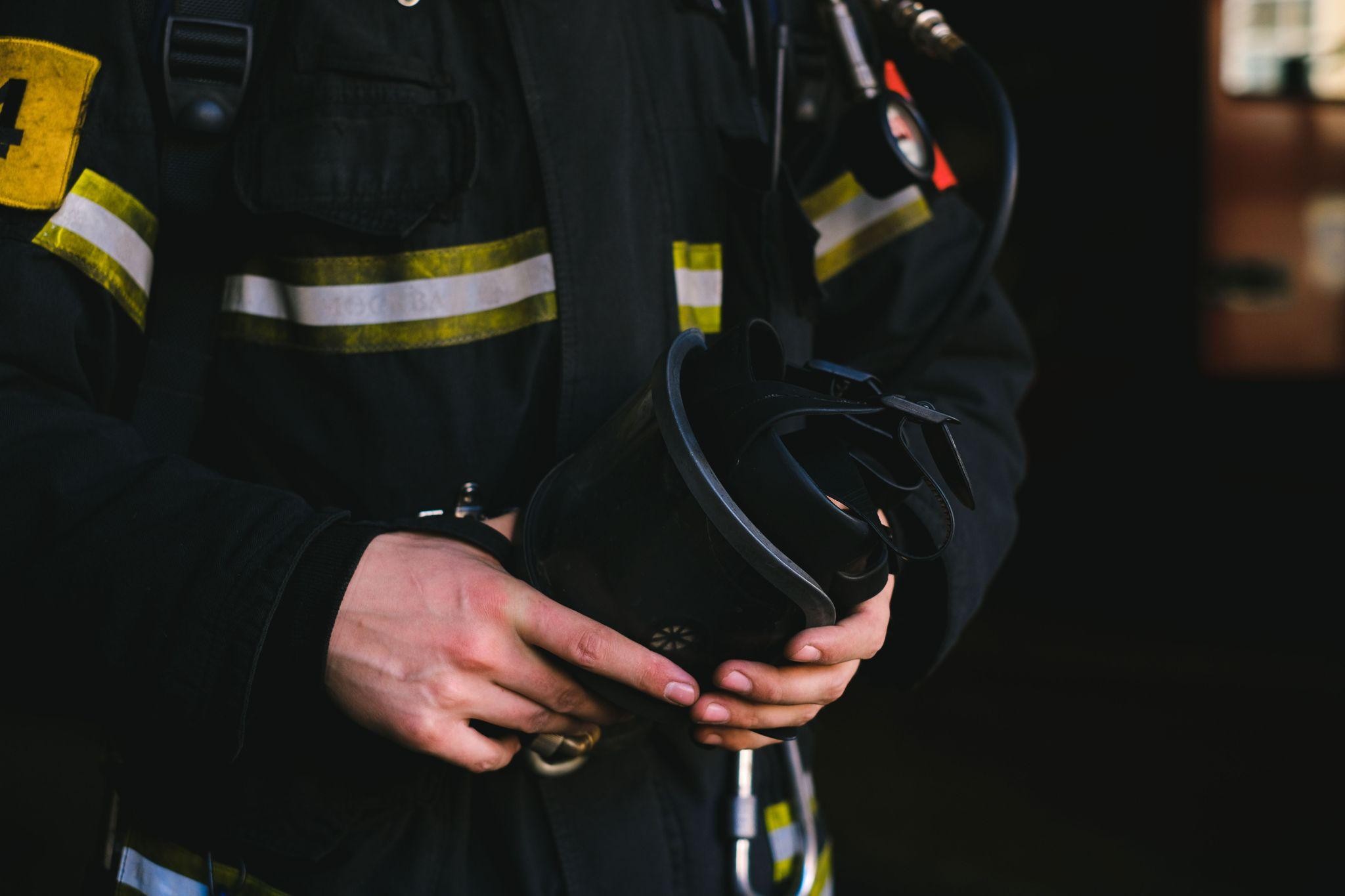 Close-up of a firefighter's hands, highlighting the uniform and gear