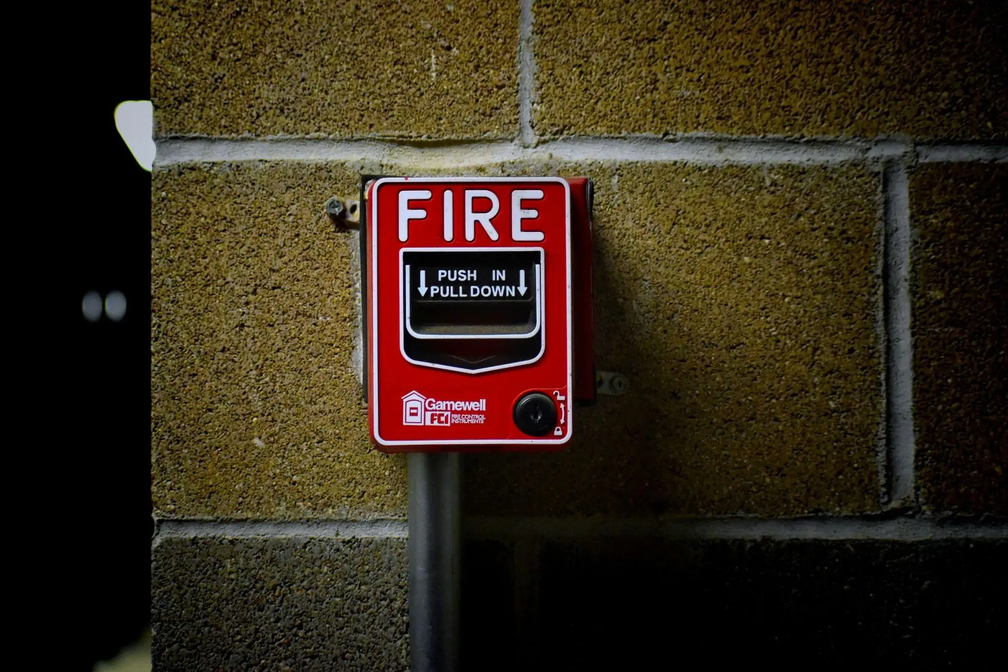 Fire alarm mounted to a cinder block wall